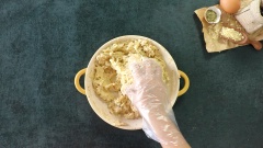 Sau đó cho vào 1 muỗng cà phê lá oregano, 1 muỗng cà phê muối và 1 muỗng cà phê tiêu. Mang bao tay và trộn đều các nguyên liệu với nhau. Tiếp theo cho vào dĩa 150gr khoai tây nghiền. Tiếp tục trộn đến khi hỗn hợp hòa quyện.
