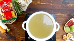 Để chuẩn bị cho phần nước dùng thì bạn cần nướng qua các loại rau củ như hành tây và hành tím, nướng chín khô mực và rang tôm khô. Bắc một nồi chứa 1 lít nước lọc lên bếp, lần lượt cho vào nồi 500gr xương heo, 80gr cà rốt, 80gr củ cải, 80gr hành tây nướng, 30gr hành tím nướng, 30gr khô mực nướng, 20gr tôm khô rang. Đun cho nước sôi rồi hớt bỏ bọt bẩn, hầm lửa nhỏ 1 tiếng đồng hồ và thường xuyên vớt bọt để nước dùng được trong. Sau đó lọc bỏ xác chỉ lấy nước dùng.