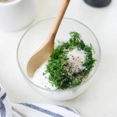 Rắc 1/2 lượng muối phủ đều trên mặt tô hỗn hợp dưa leo. Sau đó cho kem chua trộn với lá thì là thái nhỏ, lượng muối còn lại, đường, tiêu rồi cho vào tô dưa leo hành tây, trộn đều tất cả.