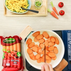 Cho 250gr xúc xích Đức vào nồi cùng 1 muỗng cà phê bơ lạt, xào săn.
