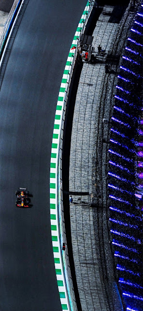 F1 Race Car Speeding on Track with Neon Lights at Night - Free mobile Wallpaper