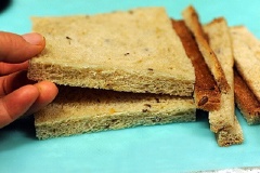 Bánh mì cắt bỏ phần diềm cứng xung quanh. Dùng thanh cán bột cán cho bánh mỏng xẹp.
