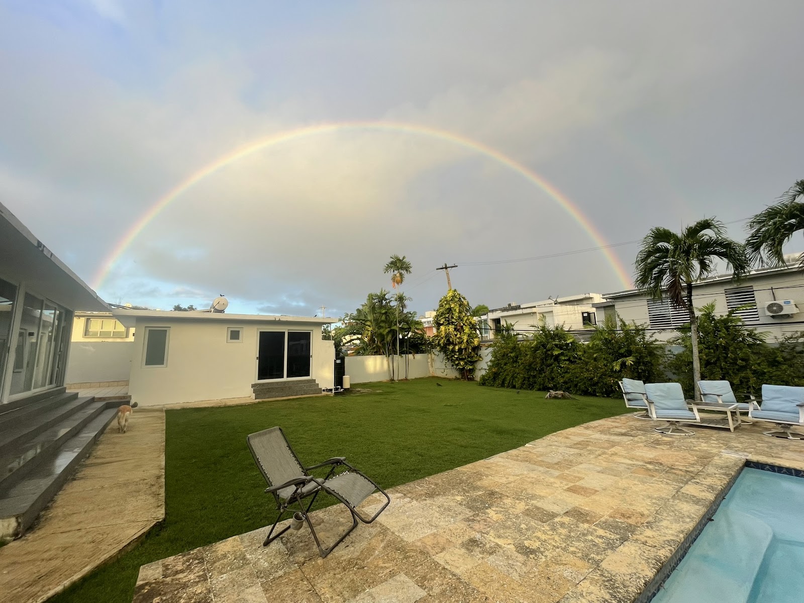 Rainbow over the backyard pool and house at The Palatial Retreat