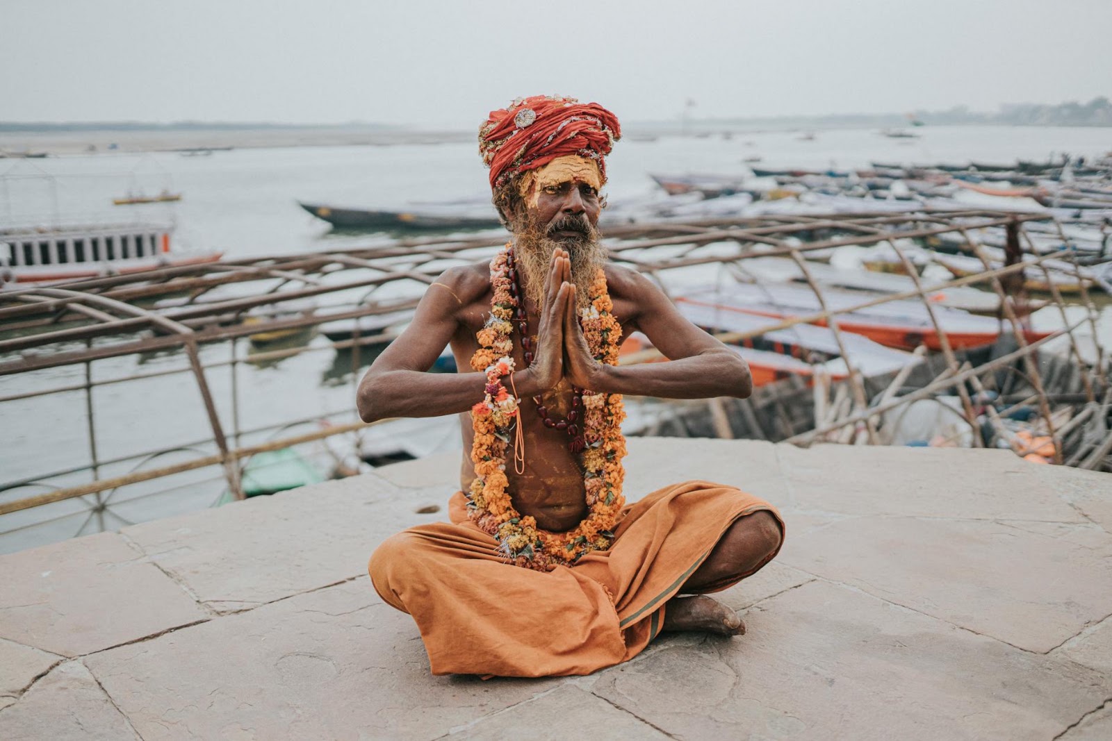 A peaceful woman meditating in a yoga pose at sunset, embodying the serene results of consistent yoga poses for stress relief and flexibility.
