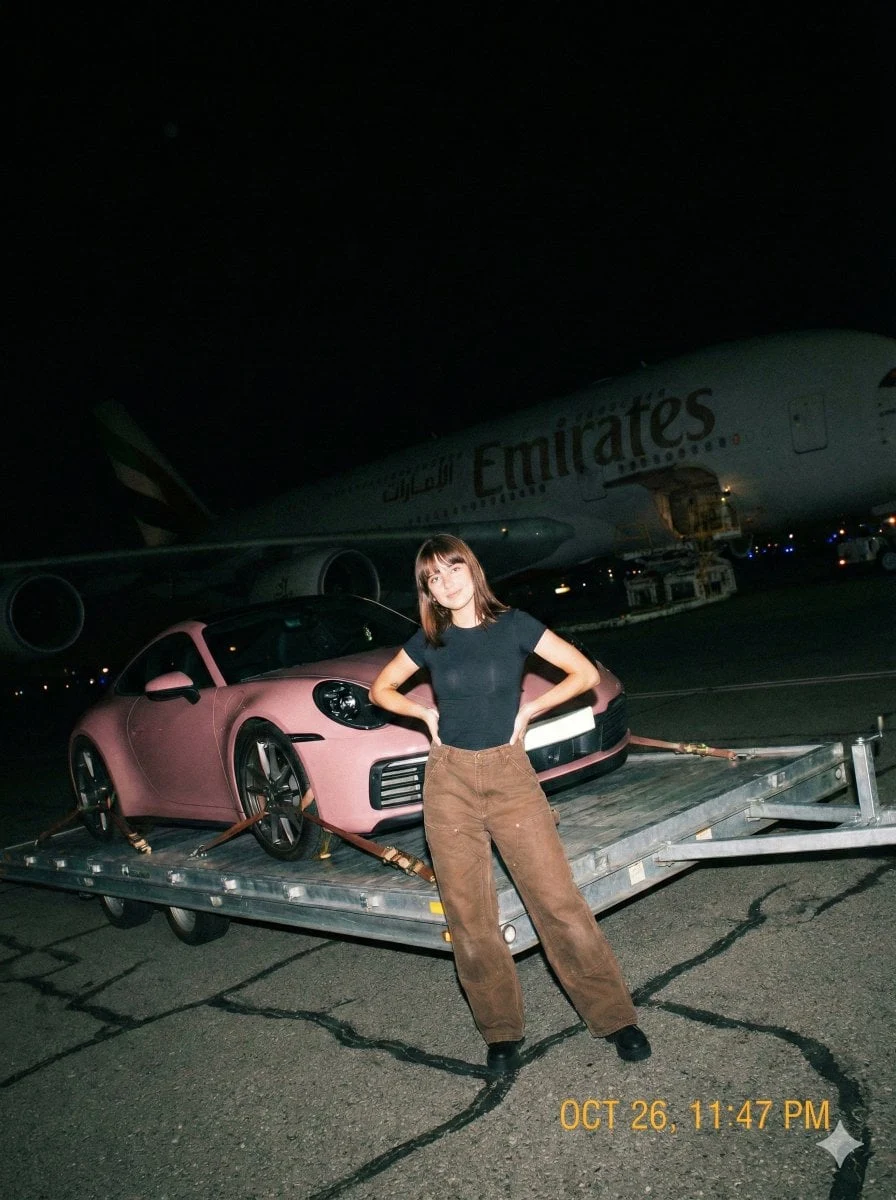 Una fotografía cruda, tomada con un iPhone a mano alzada, de noche en la pista de un aeropuerto, con un flash directo y potente.