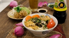 Cho bún vào tô, rắc thêm rau tía tô và hành boa rô thái nhỏ rồi thưởng thức cùng rau muống chẻ, bắp chuối, giá và rau húng quế. Tô bún nóng với vị ngọt thanh, vị chua chua hòa cùng vị béo, thơm của đậu hũ và thanh mát của rau sống ăn kèm thật sự là lựa chọn tuyệt vời cho bữa sáng hay cho bữa trưa của một ngày mùa hè đấy!