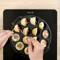 Làm nóng khuôn với lửa lớn, sau đó giảm bớt nhiệt độ rồi cho dầu ăn vào 1/3 khuôn và phần bột vào, cho tiếp bạch tuộc, hành lá, gừng hồng vào. Khi bột chín vàng thì đảo bột ngược lại và đổ thêm bột, tạo thành hình viên tròn.