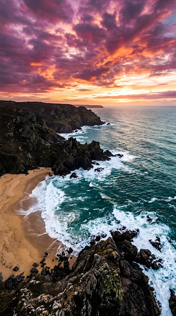 Aerial Coastline With Crashing Waves And Vibrant Purple Sunset - Free mobile Wallpaper