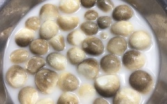 Nấm rơm cắt bỏ gốc, ngâm vào nước vo gạo khoảng 3 phút, rửa lại với nước. Sau đó, khứa chữ thập lên búp nấm.