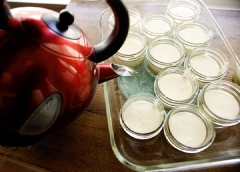 Cho hỗn hợp kem phô mai đã trộn đều vào các lọ đựng đế bánh cheesecake. Đổ nước nóng vừa đun vào khay nướng, tránh đừng để nước dính vào bánh.