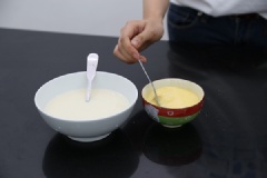 Trứng đập ra chén, đánh tan đều. Hết thời gian, lấy sữa ra, đánh tan trứng với sữa vừa được nấu xong nhé! Sau đó lọc hỗn hợp trứng qua rây cho mịn hơn.