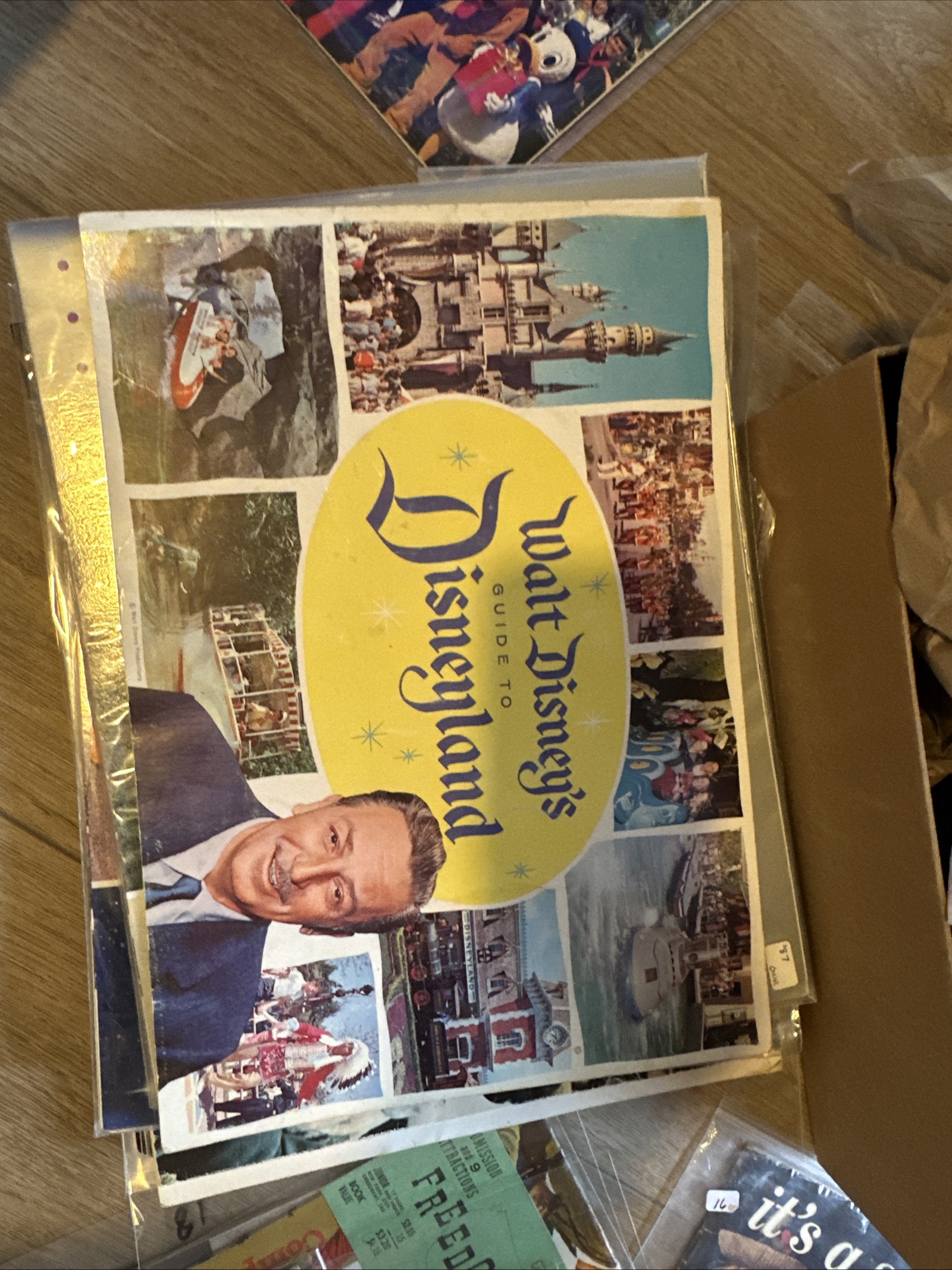 1964–1965 Walt Disney's Guide to Disneyland landscape souvenir guidebook with yellow oval cover collage featuring Walt Disney, Cinderella Castle, and park photos