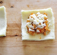 Cắt bỏ viền bánh mì rồi cán mỏng. Cho phần nhân lên rồi rắc thêm phô mai lên trên cùng.