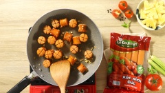 Cắt xúc xích Đức Le Gourmet thành từng đoạn nhỏ, khứa dấu cộng ở 2 đầu tạo sự đẹp mắt. Bắc chảo lên bếp, cho dầu ăn vào chảo và phi thơm 10gr tỏi băm, khi tỏi vàng thả 300gr xúc xích vào đảo cho tới khi chín vàng đẹp mắt.