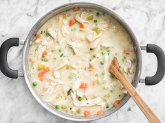Sau khi nồi canh thịt gà đã nấu chín mềm thì tắt bếp, vớt thịt gà ra và xé nhỏ. Bắt tiếp nồi canh lên bếp, đợi sôi thì cho bột bánh vào nấu chín mềm khoảng 5 phút rồi chế sữa tươi vào với 2 muỗng bột và khuấy đều lên. Cuối cùng cho ngược thịt gà vào nồi với đậu Hà Lan, ngò xắt nhuyễn, khuấy đều cho chín nguyên liệu rồi tắt bếp, nêm chút muối và tiêu cho đậm vị là xong rồi đó.