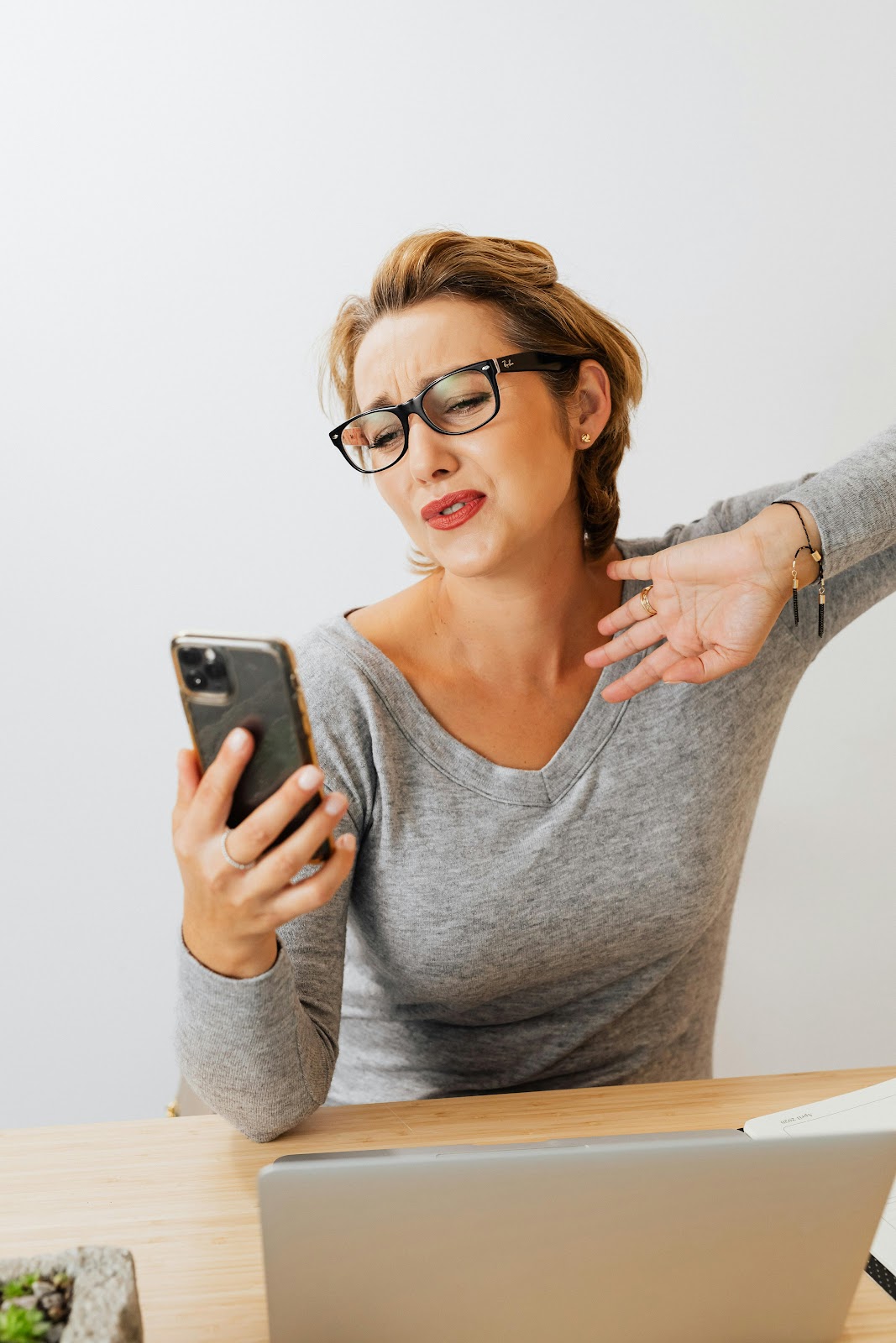 Woman looking frustrated while staring at her phone with unanswered messages