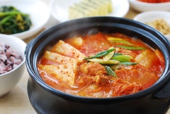 Bày trí kim chi hầm thịt ra tô lớn và dùng nóng. Món ăn nóng hổi, cay thơm kim chi, béo ngon thịt heo và đậu hũ ăn rất vừa miệng. Thích hợp cho những bữa ăn ngày lạnh đầu năm mới.