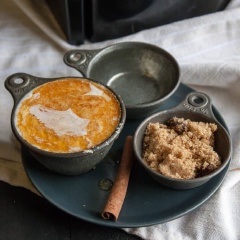 Cho heavy cream, nước và tinh chất vani vào nồi, cho thêm đường nâu cùng thanh quế vào. Bật lửa và đun nồi hỗn hợp, vừa đun vừa khuấy trong khoảng 5 phút cho hỗn hợp hòa quyện với nhau.