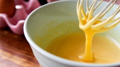 Ba lòng đỏ trứng cho vào tô cùng với 50gr đường, dùng phới lồng đánh cho đường và trứng tan đều vào nhau. Tiếp đó bạn rót vào đây 40ml dầu ăn.