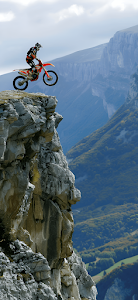 Motocross Rider Jumping Off Steep Mountain Cliff Edge