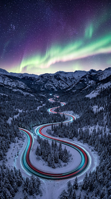 Aerial Snowy Mountain Highway beneath Northern Lights Aurora Wallpaper - Free mobile Wallpaper