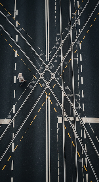 High-Angle Abstract View of a Solitary Pedestrian Walking on Wet Asphalt with Tram Tracks - Free mobile Wallpaper