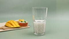 Lấy cốc cốt dừa bột báng trong tủ lạnh ra, cho sinh tố xoài lên trên, rưới thêm chút cốt dừa lên trên mặt và rắc thêm vài miếng xoài vuông để thêm phần hấp dẫn rồi thưởng thức.