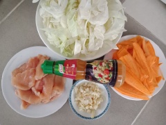 Thịt gà rửa sạch thấm khô, sau đó cắt lát mỏng. Bắp cải cắt sợi dài, dày 1cm. Cà rốt cắt mỏng theo chiều dài, sau đó cắt dọc chia làm 2. Hành lá cắt nhỏ, tỏi băm nhỏ.