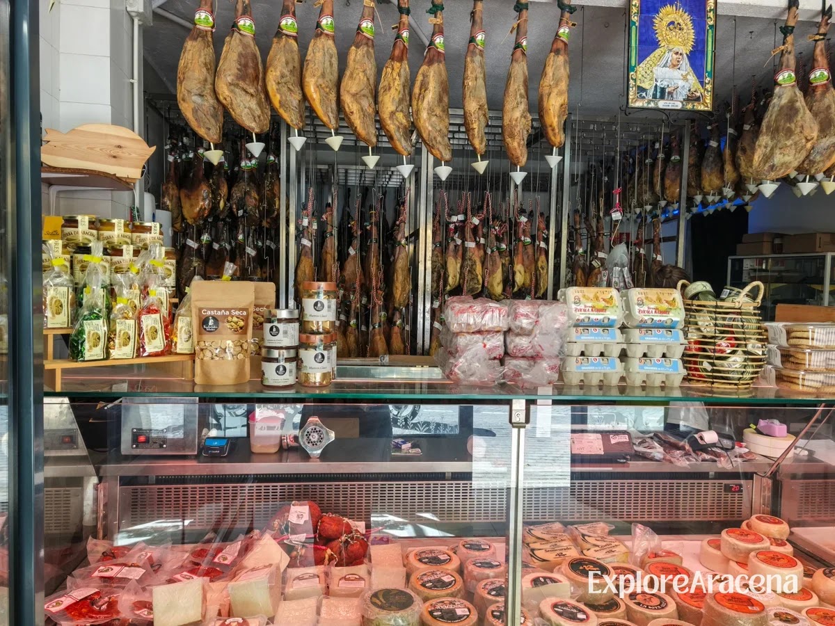 Jamón ibérico, eggs, cheeses and jars of preserves displayed inside a local shop in Aracena.