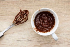 Đun chảy chocolate chips trong 15 giây ở lò vi sóng, sau đó trộn đều cùng mật ong, trứng gà, dầu dừa với nhau cho đến khi hòa quyện. Đổ bột dừa, bột nở, bột cacao rồi tiếp tục trộn, cho vào cốc. Nướng bánh trong 1 phút - 1 phút 30 giây là hoàn thành.