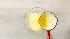 Cho vào tô thuỷ tinh 250gr cream cheese, dùng phới dẹt dằm mịn, sau đó cho vào 50gr đường, dùng phới lồng trộn đều. Cho phần nước cam vào hỗn hợp, trộn đều bằng phới lần nữa. Tiếp tục cho vào tô 150gr whipping cream, 3 giọt màu vàng thực phẩm, trộn đều bằng phới lần nữa đến khi hỗn hợp hoà quyện.