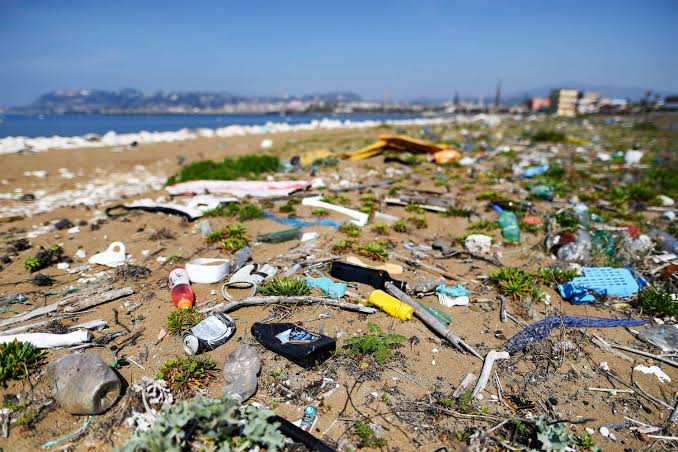 A beach covered in plastic pollution. Plastic waste, Personal care and cosmetics waste, plastic waste footprint, plastic microbeads cosmetic waste, marine ecosystem. CarbonEthics Indonesia