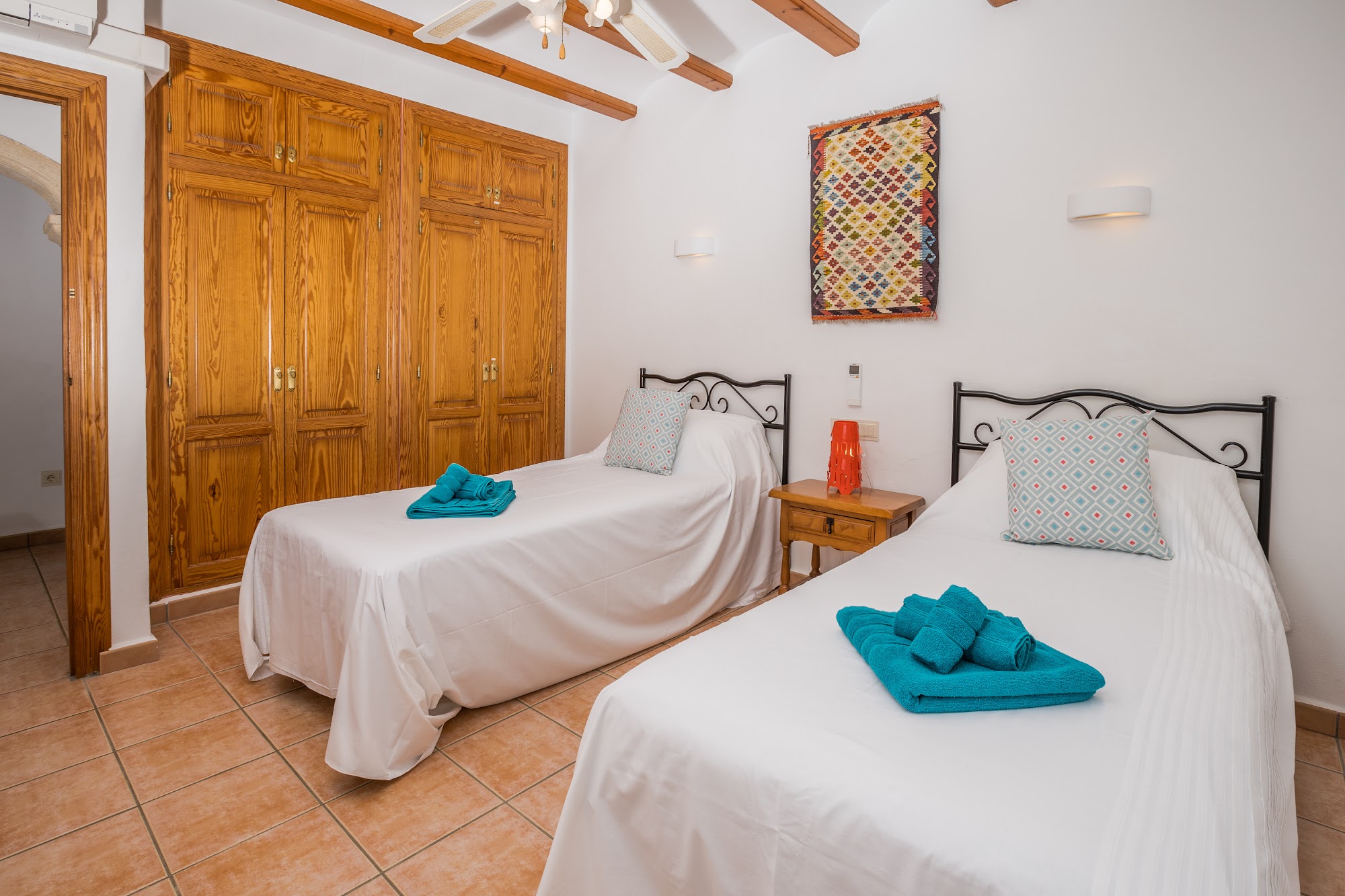 Twin bedroom with turquoise towel accents