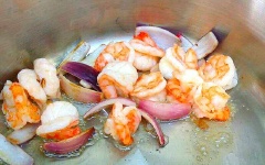 Phi thơm hành tím với 2 muỗng canh dầu ăn. Cho tôm tươi vào, xào cho tôm săn lại.