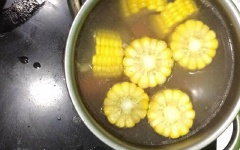 Khi nước sôi, cho bắp mỹ, cà rốt, khoai tây vào, nấu sôi 5 phút. Nêm gia vị 1 muỗng cà phê muối, 1 muỗng cà phê hạt nêm, 1/2 muỗng cà phê bột ngọt cho vừa ăn.