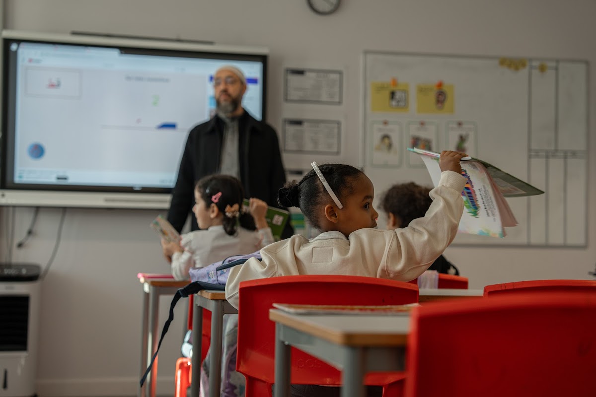 Student raising her hand in Arabic class