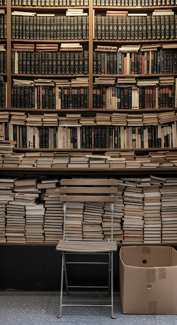 Front View of an Antique Bookseller's Stall with Stacked Vintage Books - Free mobile Wallpaper