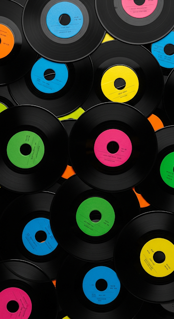 Overhead View of Overlapping Black Vinyl 45 RPM Records with Colorful Labels - Free mobile Wallpaper