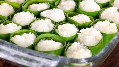 Đến bước vo viên cơm rượu. Bạn có thể chuẩn bị những dây lá chuối để quấn sẽ giúp cố định hình dạng, giúp cơm rượu không dính vào nhau và không bị vỡ nát. Sử dụng bao tay để vo sẽ giúp cơm rượu để được lâu hơn vì không tiếp xúc với mồ hôi. Nhúng bao tay vào nước pha men, vo lần lượt những viên cơm rượu cho đến khi hết số xôi nếp. Xếp cơm rượu vào một chiếc khay, nồi hoặc hộp lớn, bọc kín rồi để ở nơi ấm áp và khô ráo để cơm rượu nhanh lên men hơn.