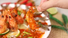 Bày tôm ra đĩa, xếp các lát chanh xung quanh, chan nước sốt mắm nhĩ lên mặt, rắc lên ngò gai lên mặt. Tôm khi ăn có vị mềm dai sần sật nhai vui miệng, chan với sốt mắm nhĩ Thái hấp dẫn. Phần đầu tôm không bỏ đi mà đem chiên với bột bắp giòn giòn, vừa béo vừa bùi rất thú vị. Ăn kèm với đó là bánh tráng nướng giòn chấm với nước sốt ngon không cưỡng nổi.