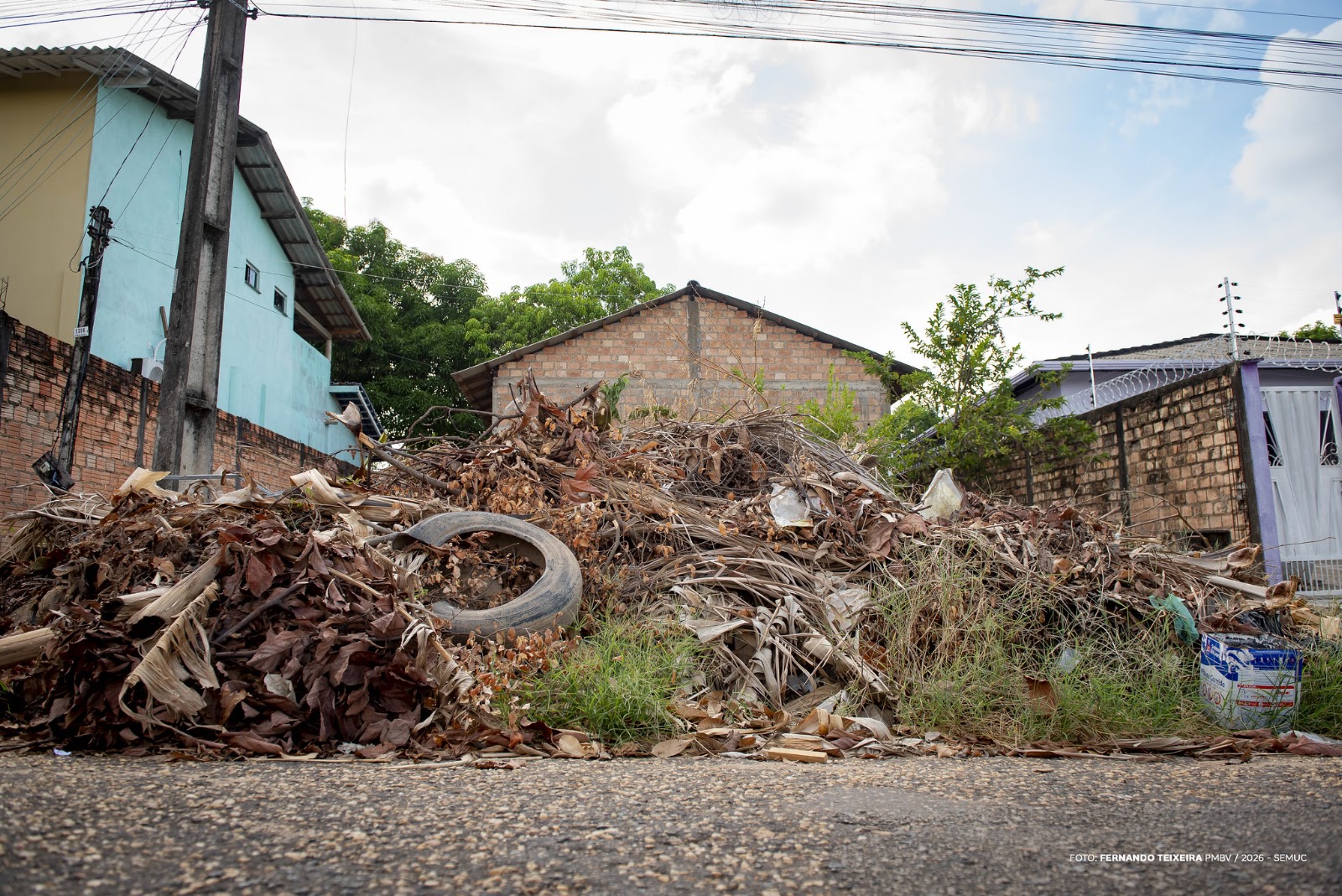 Máquina retroescavadeira limpa vala de escoamento para prevenir alagamentos como parte da limpeza urbana em Boa Vista.