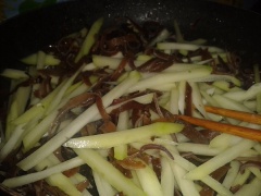 Để chảo đó, cho thêm dầu và cho su su, nấm mèo vào xào nhanh, múc 1 muỗng canh gia vị (đã chuẩn bị trước), đảo đều. Đến khi su su và nấm chín, đổ ra tô để riêng.
