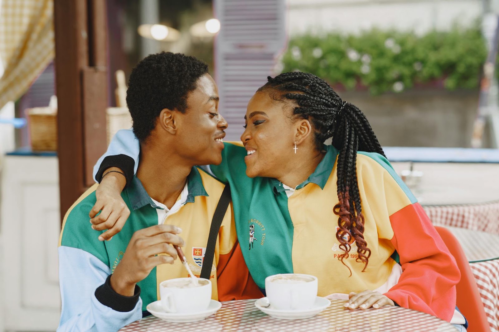Two people having an authentic human connection in a bustling coffee shop, a stark contrast to the rise of AI dating apps.