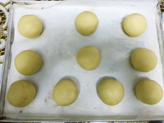 Đặt vào viên bột 30gr nhân đậu xanh, 1 viên mochi, 1 muỗng canh chà bông sau đó gói lại. Phết mặt bánh với lòng đỏ đánh tan, rắc một ít mè. Và nướng bánh ở 190C trong vòng 25 phút hoặc đến khi vỏ banh chuyển sau màu nâu vàng óng.