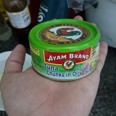 Cho cá ngừ đóng hộp ra tô. Thêm gia vị tiêu, sốt mayonnaise và nặn 1 lát chanh đã chuẩn bị vào, dầm nát rồi trộn đều tay.
