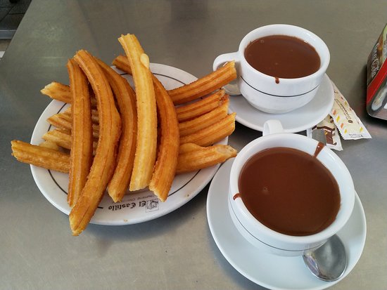 Fresh churros served with thick hot chocolate at Churrería Chocolatería Castillo in Aracena.