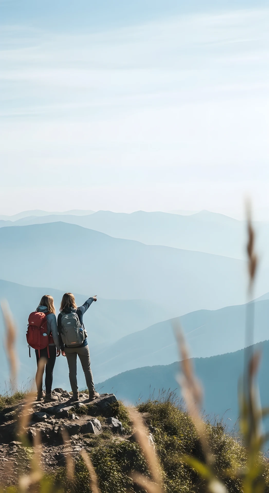 Two Hikers Viewing Layered Blue Mountain Vista - Free 4K mobile Wallpaper