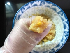 Cho thịt ức gà xay nhuyễn vào tô củ năng và bắp hột, thêm 1/4 muỗng cà phê muối, 1/2 muỗng cà phê muối, 10ml rượu nấu ăn, ít gừng băm, đập 1 quả trứng cho vào. Mang bao tay nylon rồi nhồi cho hỗn hợp thịt viên được quyện đều.