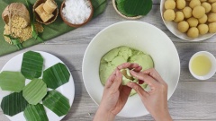 Sau khi bột nghỉ đủ, thoa một ít dầu ăn vào tay. Lấy khoảng 30gr bột, ấn dẹt bột thành hình tròn, cho từng viên nhân đậu xanh dừa vào giữa. Dùng tay miết phần vỏ bao bọc viên nhân và vo tròn từng cái bánh.