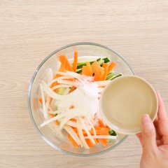 Cho 50gr cà rốt cắt thanh dài, 50gr củ cải trắng cắt thanh dài, 50gr dưa leo cắt thanh dài, 50gr hành tây cắt sợi vào tô trộn đều cùng 3 muỗng canh đường, 3 muỗng canh giấm, 400ml nước lọc. Ngâm rau củ cho đến khi mềm và vớt ra để ráo.